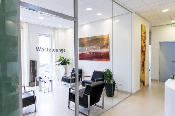 Zahnarzt_Gehl_Praxis_10 Wartelounge von Zahnarztpraxis mit Bildern und schwarzen Sesseln